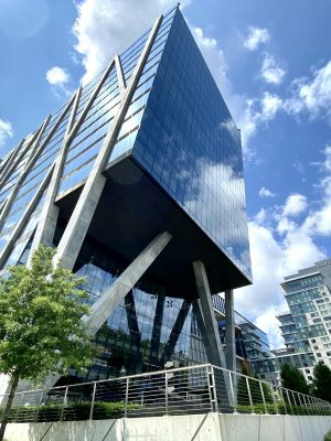 A striking modern office building with glass facade in Reston, VA under a clear blue sky.